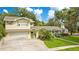 Exterior of a two-story home surrounded by mature trees and a green lawn, showcasing its charming curb appeal at 606 N Mcdonald St, Mount Dora, FL 32757