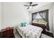 Bedroom features a large window, ceiling fan, and patterned bedspread at 6080 Fender Ct, Orlando, FL 32837