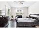 This bedroom has hardwood floors, ceiling fan, and window with sheer patterned curtains at 6080 Fender Ct, Orlando, FL 32837
