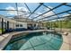 Enclosed pool with furniture, grill, jacuzzi, and view of the home at 6080 Fender Ct, Orlando, FL 32837