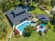 Stunning aerial view of a house with a large pool and beautifully landscaped backyard and patio area at 6464 Timberwind Pl, Orlando, FL 32818