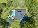 Aerial view of a private residence featuring a swimming pool, patio area, and mature landscaping in a serene setting at 6464 Timberwind Pl, Orlando, FL 32818