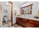 Bathroom with wooden vanity, decorative mirror, and colorful tiled flooring at 6464 Timberwind Pl, Orlando, FL 32818