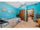 Bedroom with blue walls, louvered closet doors, and view into office with built-in shelving at 6464 Timberwind Pl, Orlando, FL 32818