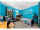 Bright blue bedroom with cozy furnishings, a vaulted ceiling, and a window view at 6464 Timberwind Pl, Orlando, FL 32818