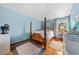 Cozy bedroom with a four-poster bed, hardwood floors, and natural light from the window at 6464 Timberwind Pl, Orlando, FL 32818
