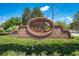 Autumn Chase community sign featuring brickwork, lush greenery, and clear lettering under a bright, sunny sky at 6464 Timberwind Pl, Orlando, FL 32818