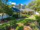 Charming home featuring lush landscaping, a winding walkway, and unique architectural details at 6464 Timberwind Pl, Orlando, FL 32818