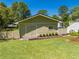 The exterior of a home features an outbuilding with simple landscaping and a large grassy area at 6464 Timberwind Pl, Orlando, FL 32818