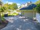 Home's garage and additional building highlighting the large driveway and exterior features at 6464 Timberwind Pl, Orlando, FL 32818