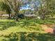 Scenic view of a home surrounded by mature trees and a large, well-maintained lawn creating a serene setting at 6464 Timberwind Pl, Orlando, FL 32818