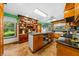Open kitchen featuring custom cabinets, an island, and stainless steel appliances at 6464 Timberwind Pl, Orlando, FL 32818