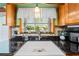 Farmhouse kitchen sink with granite countertops and a tiled backsplash at 6464 Timberwind Pl, Orlando, FL 32818