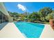 Backyard pool, outdoor seating and tropical landscaping at 6464 Timberwind Pl, Orlando, FL 32818