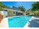 Backyard featuring pool, screened in patio, cabana and green landscaping at 6464 Timberwind Pl, Orlando, FL 32818
