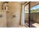 Tiled shower with glass door to outside patio and shower accessories at 6464 Timberwind Pl, Orlando, FL 32818