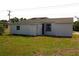 Backyard view of a white house showing a small window and door at 709 28Th Nw St, Winter Haven, FL 33881