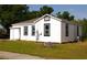 Exterior view of a white house with a green lawn and black trimmed windows at 709 28Th Nw St, Winter Haven, FL 33881