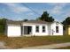 Exterior front view of a white house with a covered porch and black trimmed windows at 709 28Th Nw St, Winter Haven, FL 33881