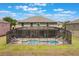 A serene backyard featuring a screened pool and ample lounging space at 8571 La Isla Dr, Kissimmee, FL 34747