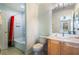 Bright bathroom with light tile, light wood vanity and red floral print shower curtain at 8571 La Isla Dr, Kissimmee, FL 34747