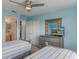 Bedroom with twin beds, ceiling fan, dresser, and bath access at 8571 La Isla Dr, Kissimmee, FL 34747
