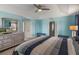 Spacious bedroom with tray ceiling, ceiling fan and adjacent bathroom and closet entrances at 8571 La Isla Dr, Kissimmee, FL 34747