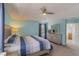 Serene bedroom with a tray ceiling, ceiling fan, a large bed and an adjacent bathroom at 8571 La Isla Dr, Kissimmee, FL 34747
