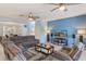 Open-concept living room with a cozy sectional sofa, TV, and seamless flow to the dining area at 8571 La Isla Dr, Kissimmee, FL 34747