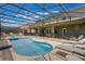 Beautiful in-ground pool with expansive screened enclosure, seating, and ample lounging space at 8571 La Isla Dr, Kissimmee, FL 34747