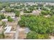 An aerial view of a house surrounded by trees in a neighborhood with other houses nearby on a sunny day at 918 Louise Ln, Deland, FL 32720