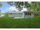View of the house from the backyard with a manicured lawn and patio at 918 Louise Ln, Deland, FL 32720
