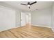 Bright bedroom featuring light wood floors, a ceiling fan and a closet with white doors at 918 Louise Ln, Deland, FL 32720
