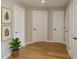 Bright hallway featuring wood floors and several doors with modern hardware at 918 Louise Ln, Deland, FL 32720