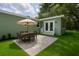 Inviting outdoor patio features a dining table with umbrella and well-manicured lawn, perfect for relaxing and entertaining at 918 Louise Ln, Deland, FL 32720