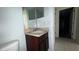Bathroom with sink and dark wood vanity, plus an electrical outlet and access to the hallway at 979 Hacienda Cir, Kissimmee, FL 34741