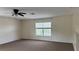A well-lit bedroom with neutral walls and brown carpet, complete with a ceiling fan at 979 Hacienda Cir, Kissimmee, FL 34741
