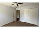A bedroom features a ceiling fan, closet with doors, and neutral paint at 979 Hacienda Cir, Kissimmee, FL 34741