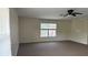 Bonus room with neutral paint, a ceiling fan and tan carpet with a window at 979 Hacienda Cir, Kissimmee, FL 34741