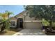 Charming home featuring an attached two-car garage and well-maintained landscaping, including a palm tree at 979 Hacienda Cir, Kissimmee, FL 34741