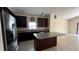 Spacious kitchen boasting dark wood cabinets, granite countertops, stainless steel appliances, and an island at 979 Hacienda Cir, Kissimmee, FL 34741