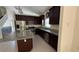 Modern kitchen with granite counters, stainless appliances, center island and dark wood cabinetry at 979 Hacienda Cir, Kissimmee, FL 34741