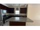 Features include dark wood cabinets, granite countertops, stainless steel appliances and a large island at 979 Hacienda Cir, Kissimmee, FL 34741