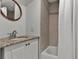 Cozy bathroom with a granite vanity top, white cabinets, a decorative mirror, and a shower and tub combo at 1012 N Shine Ave, Orlando, FL 32803