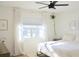 Serene bedroom with a ceiling fan, white walls, light-colored curtains, and natural sunlight at 1012 N Shine Ave, Orlando, FL 32803