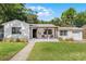 Charming single-story home with a covered porch, patterned patio, and beautiful landscaping at 1012 N Shine Ave, Orlando, FL 32803