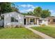 Inviting single-story home with a covered porch, patterned patio, and well-manicured lawn at 1012 N Shine Ave, Orlando, FL 32803