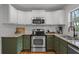 Updated kitchen featuring stainless steel appliances, granite counters, and stylish two-tone cabinetry at 1012 N Shine Ave, Orlando, FL 32803