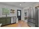 Bright kitchen showcasing stainless steel fridge, stylish sink, and access to both dining area and backyard at 1012 N Shine Ave, Orlando, FL 32803