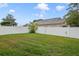 Spacious fenced back yard with green grass and a banana tree in a sunny suburban setting at 102 Royalty Cir, Sanford, FL 32771